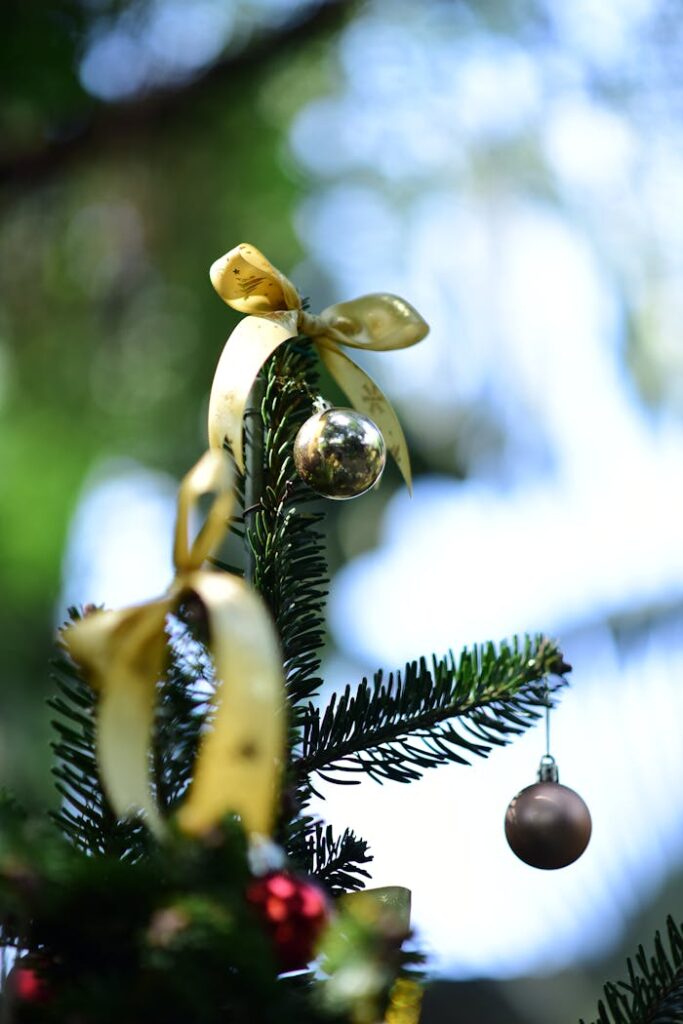 Elegant Christmas tree adorned with shiny golden ornaments and ribbons, celebrating the festive season.
